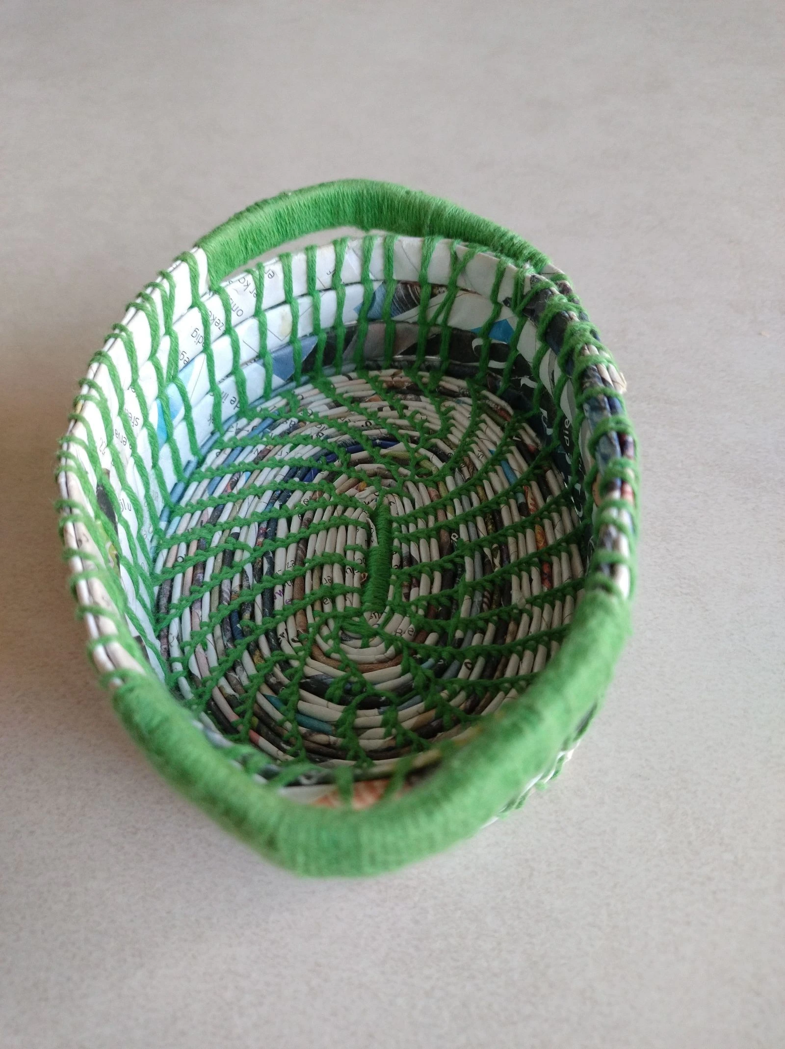 Mandje handgemaakt van papier stroken. Aan elkaar genaaid met katoengaren